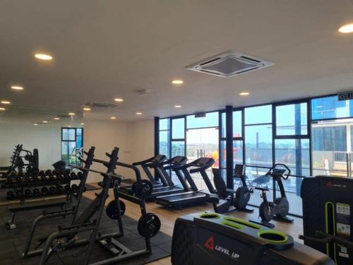 a gym with treadmills and ellipticals in a room with windows at Premium Swanhouse no.SiX with 3bedrooms Condo in Sibu