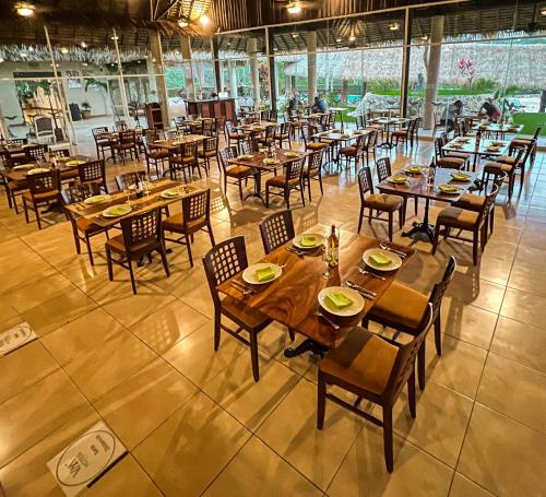 an empty restaurant with wooden tables and chairs at Hotel Villa Mercedes Palenque in Palenque