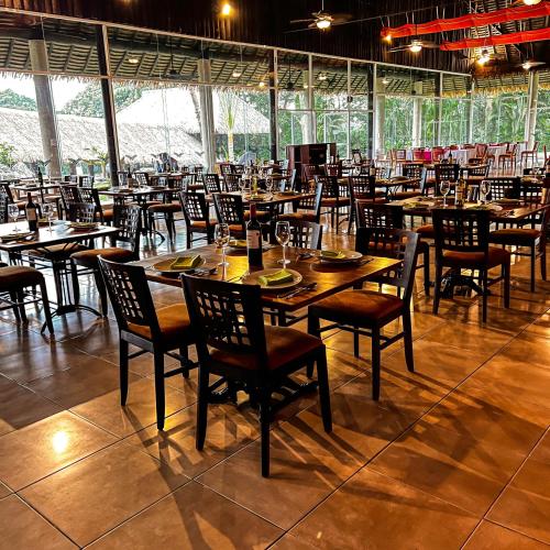 a dining room with wooden tables and chairs at Hotel Villa Mercedes Palenque in Palenque