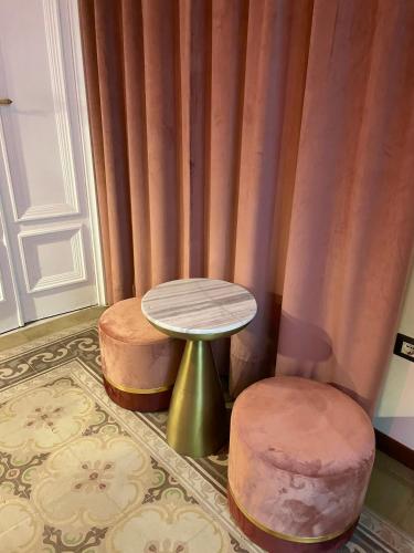 a room with a table and two stools at PALAZZO FIACCADORI - Historical Palace in Reggio Calabria
