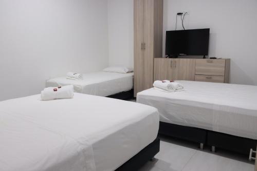 a bedroom with two beds and a tv in it at OMA HOTEL LA GUAJIRA in Camarones