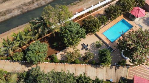 an aerial view of a backyard with a pool and trees at Karjat retreat 4bhk pvt farmhouse in Karjat