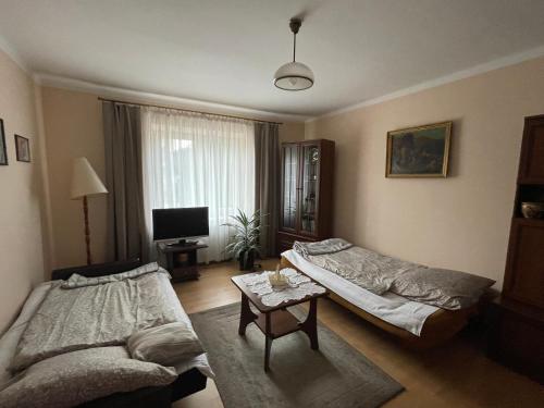 a living room with two beds and a table at Apartament in Bochnia