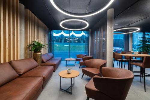 a lobby with a couch and chairs and tables at ALPSTADT LIFESTYLE Hotel in Bludenz