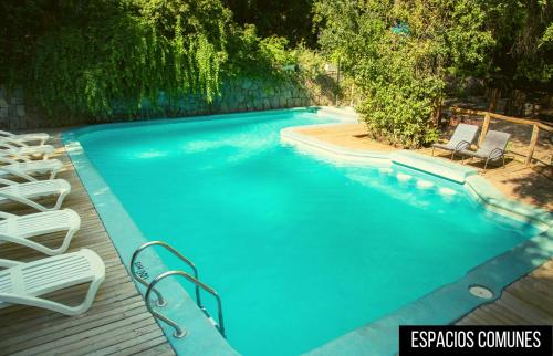 a swimming pool with lounge chairs and a swimming pool at Cabañas Piedra Luna in San Alfonso