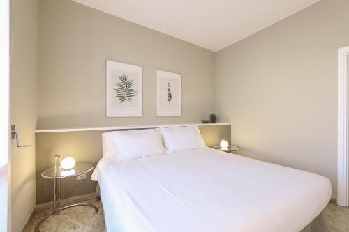 sypialnia z białym łóżkiem i 2 bocznymi stolikami w obiekcie Contempora Apartments - Elvezia 8 - E51 w Mediolanie