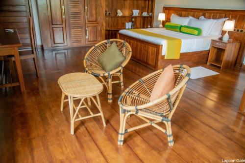 a bedroom with a bed and two chairs and a table at Lagoon gate Tangalle Resort in Tangalle
