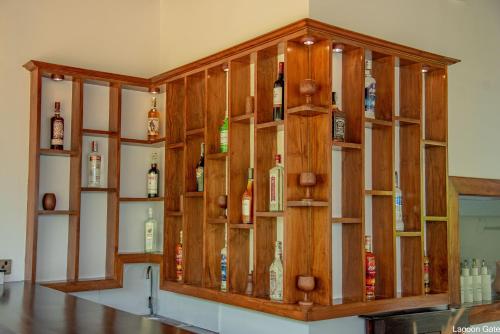 a wooden cabinet filled with bottles of alcohol at Lagoon gate Tangalle Resort in Tangalle