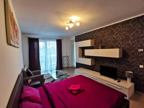 una camera da letto con un letto rosa e una scrivania di Contemporary central apartment in Cluj Napoca a Cluj-Napoca