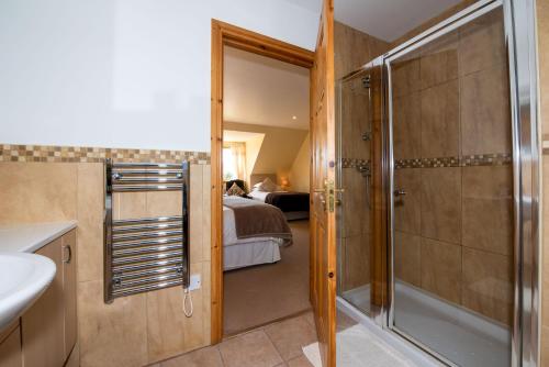 牛顿莫尔Tigh an Each B&B & Laggan Glamping的带淋浴和盥洗盆的浴室以及1张床。
