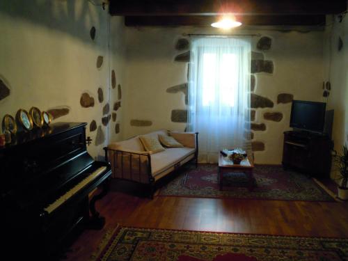 een woonkamer met een bank en een piano bij Casa Castori in Macomer