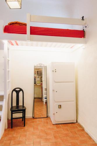 a room with a bunk bed and a chair at Casa Caracol in Cádiz