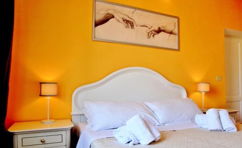 a bedroom with a white bed with an orange wall at Vista San Pietro in Rome