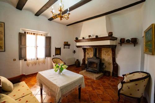 un soggiorno con tavolo e camino di Casa Rural Moliner a Las Cuevas de Cañart