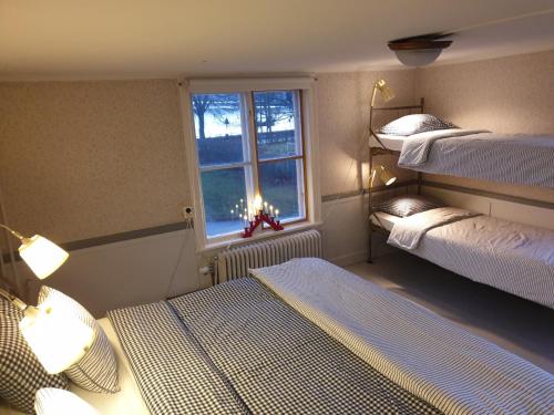 Zimmer mit 2 Etagenbetten und einem Fenster in der Unterkunft Djurgårdsportens vandrarhem in Mariefred