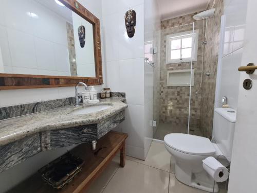 uma casa de banho com um lavatório, um WC e um chuveiro em Flat 31 SUN HOUSE Maresias em Maresias