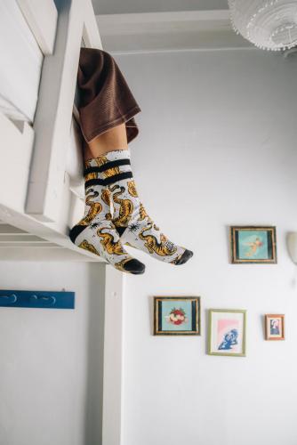 a person in colorful socks is sitting on a shelf at Casa Caracol in Cádiz