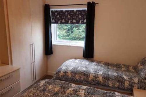 1 dormitorio con 2 camas y ventana en 3 BedroomHouse For Corporate Stays in Kettering, en Kettering