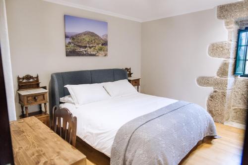 a bedroom with a bed and a table in it at Casa Quinteliña in Lugo