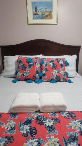 a bed with red and white sheets and pillows at Blue Spruce Bed and Breakfast Muskoka in Gravenhurst