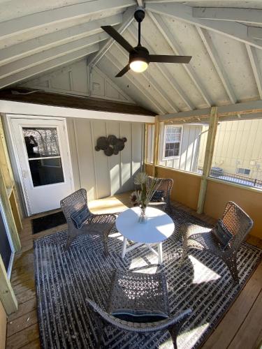 a porch with a table and chairs and a ceiling fan at Here It Is! Cool Cape Cod-3 BR-2.5 Bath-12 Guests in Olathe