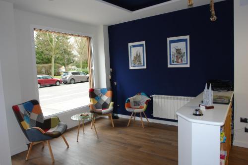a living room with blue walls and a table and chairs at Hostal Campus in Burgos