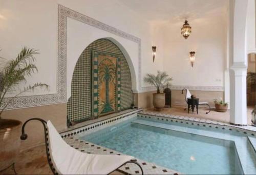 een groot zwembad in een kamer met een zwembad bij Riad Dar Talah in Marrakesh