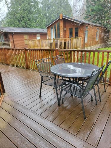 a patio with a table and chairs on a deck at Cheerful 3 bedroom Lodge At White cross Bay Windermere in Windermere