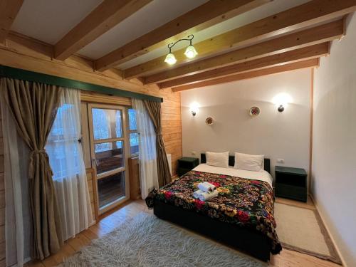 Schlafzimmer mit einem Bett und einem Fenster in der Unterkunft Pensiunea Iza in Vişeu de Jos