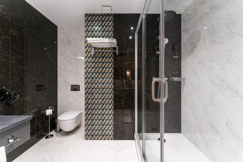 uma casa de banho com uma cabina de duche em vidro e um WC. em Old Riga Plaza Hotel em Riga