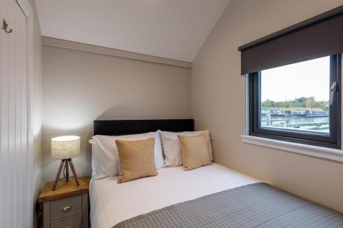 a bedroom with a bed and a window at Tattenhall Marina Floating Pods in Hargrave