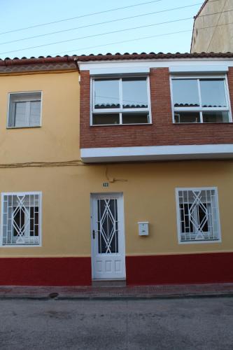 a yellow and red house with a white door at Casa Victor in Benissanet