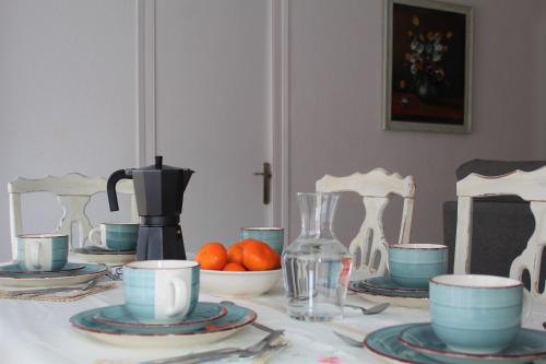 uma mesa com pratos e chávenas e uma máquina de café em Casa Victor em Benissanet