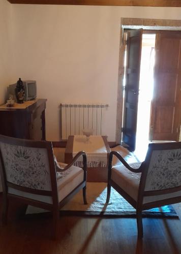 a bedroom with two chairs and a bed and a window at Casa Do Seminario in Gralhas