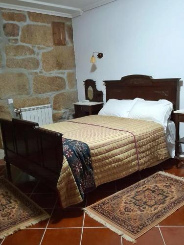a bedroom with a bed and two rugs on the floor at Casa Do Seminario in Gralhas