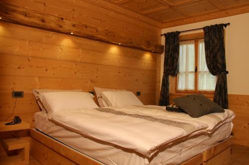 a bedroom with a bed in a wooden cabin at Jägerhaus Agriturismo in Cortina dʼAmpezzo