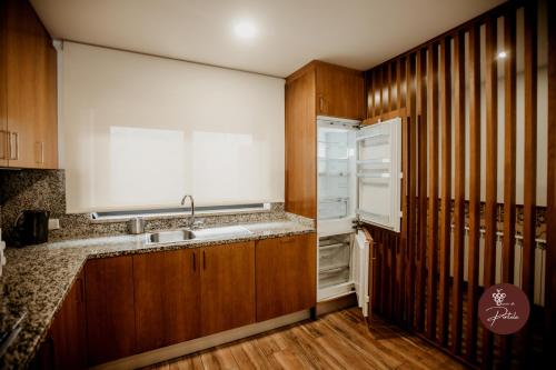 a kitchen with a sink and a refrigerator at Casa da Adega - Quinta da Portela in Terras de Bouro
