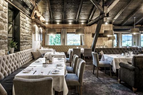 a restaurant with white tables and chairs and windows at Landhotel Das Stocker in Vorderstoder