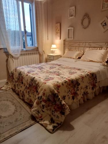 1 dormitorio con 1 cama con colcha de flores en Casa Alex, en Cascina