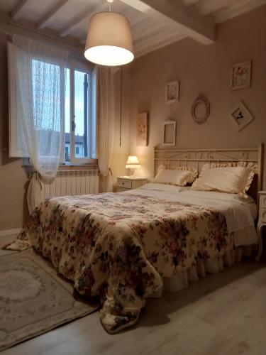 Un dormitorio con una cama grande con una manta de flores en Casa Alex, en Cascina