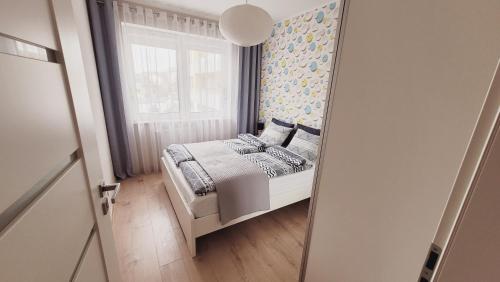 コウォブジェクにあるApartament Miodowy Domの小さなベッドルーム(ベッド1台、鏡付)