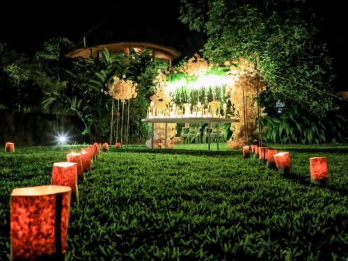 a garden at night with chairs and lights at Divine Resort & Spa in Kampala