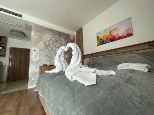 a bedroom with a bed with a towel animal on it at Great Time Apartman in Hévíz