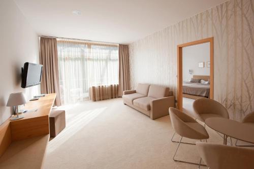 a living room with a couch and a mirror at Špik Alpine Resort in Kranjska Gora