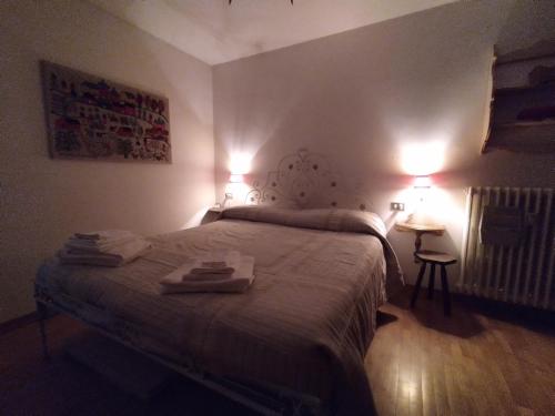 a bedroom with a bed with two towels on it at MEADOWS Apartment in Ponte di Legno