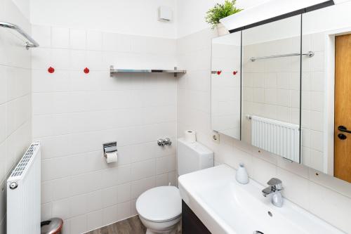 a white bathroom with a toilet and a sink at Haus Mühlentrift in Cuxhaven