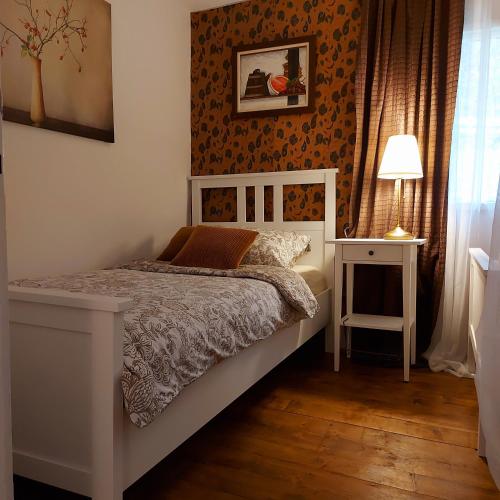 a bedroom with a bed and a table and a lamp at Honey house Lika in Gospić