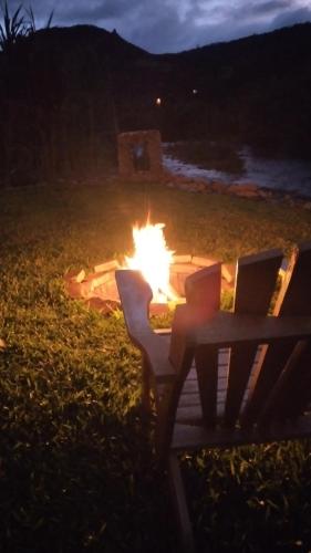 a fire pit with two laptops sitting next to a bench at Pousada Sentiero in Urubici