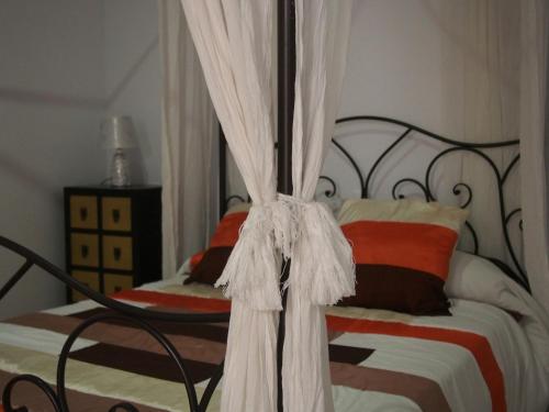 a bedroom with a bed with a black frame and curtains at Apartamento Barbancho in Cáceres