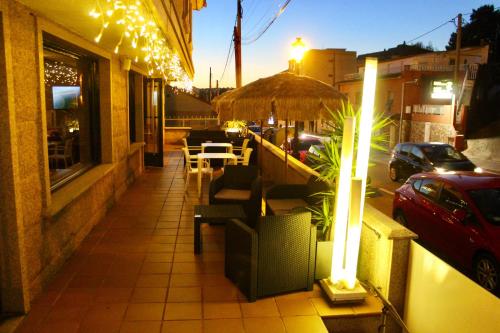 a building with a table and chairs on a sidewalk at Hostal Casa Aurita Adults Only in Sanxenxo